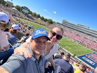 a man and woman taking a selfie at a football game