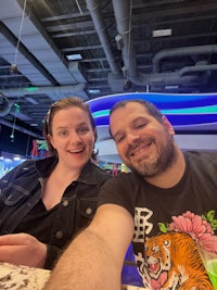 a man and woman taking a selfie at a bowling alley